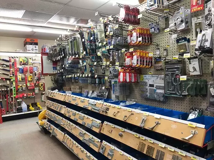 Retail hardware aisle at Great Lakes Rona featuring door hinges, gate latches, hooks, and various metal fasteners on pegboard displays.