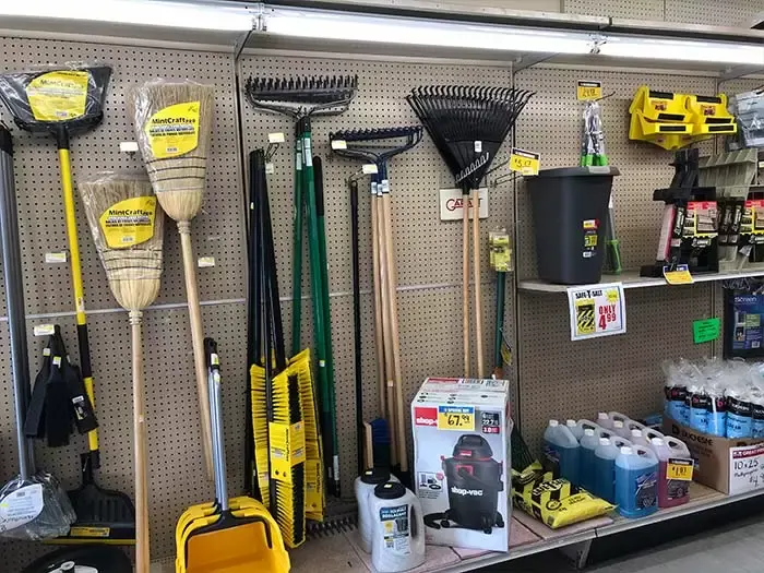A retail display at Great Lakes Rona featuring heavy-duty brooms, rakes, shop vacuums, and winter maintenance supplies.