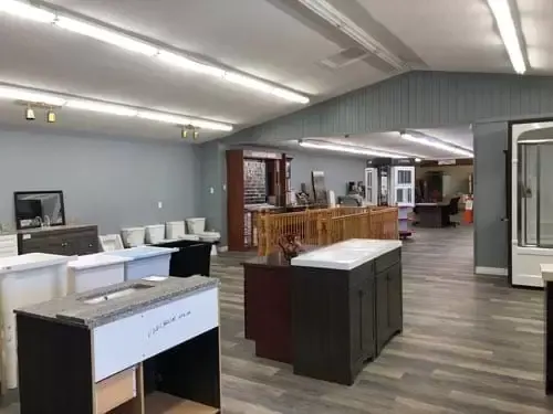 Interior of a home remodeling showroom featuring bathroom vanities, sinks, and toilets on display.